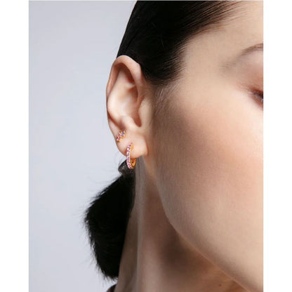 Close-up of a woman wearing elegant earrings, showcasing the design and fit of jewelry.