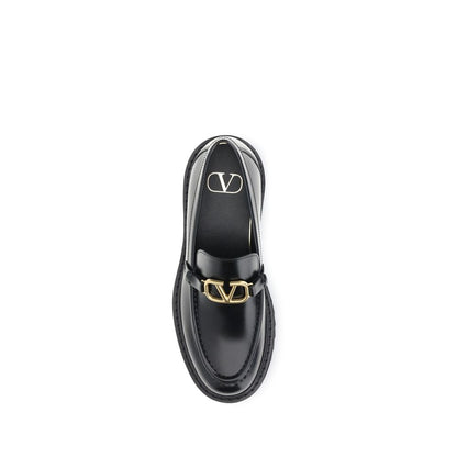 Valentino Garavani Black Leather Slip-On Loafers with VLogo detail and rubber lug sole.