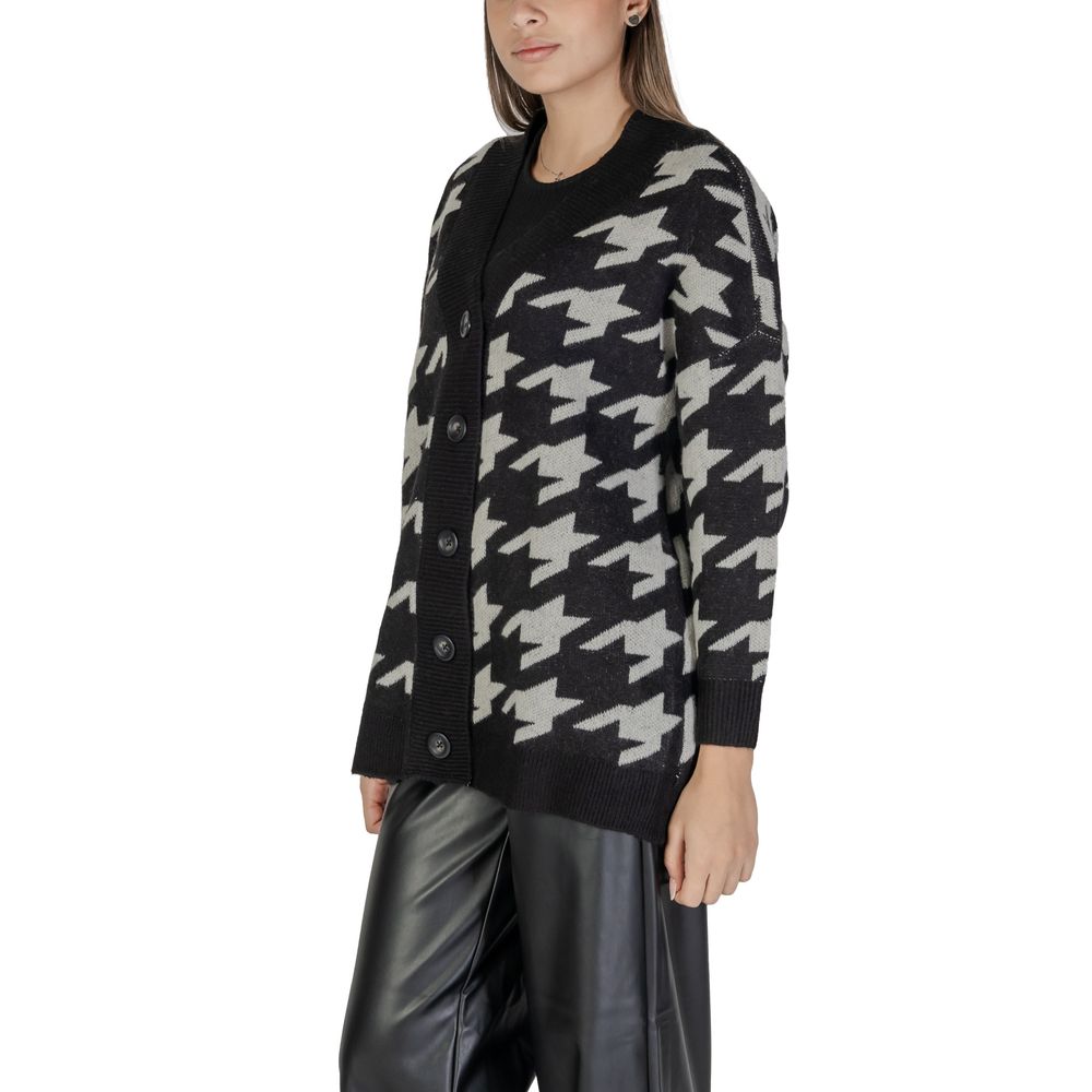 Woman wearing Vero Moda Black And White Marabou Cardigan with oversized houndstooth pattern, perfect for autumn and winter fashion.