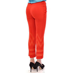 Model wearing Versace Collection Red Pants Cropped 3/4 Short Nude Capri Pants with unique leg pattern, rear view.