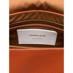 Interior label of Zanellato Postina Daily Small leather handbag showing 'Made in Italy' and brand name inside orange handbag.