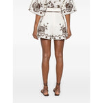 Back view of model wearing Zimmermann Ascension Shorts, featuring light beige linen, scallop edge, and detachable waist belt.