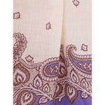 Close-up of paisley pattern on fabric in ecru and purple hues, showcasing intricate design details.