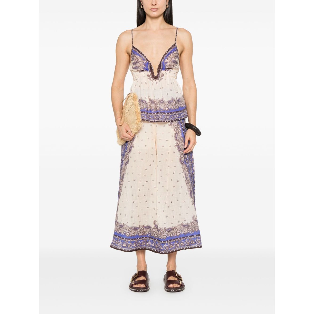 Woman wearing a summer dress with intricate lace details and holding a woven bag